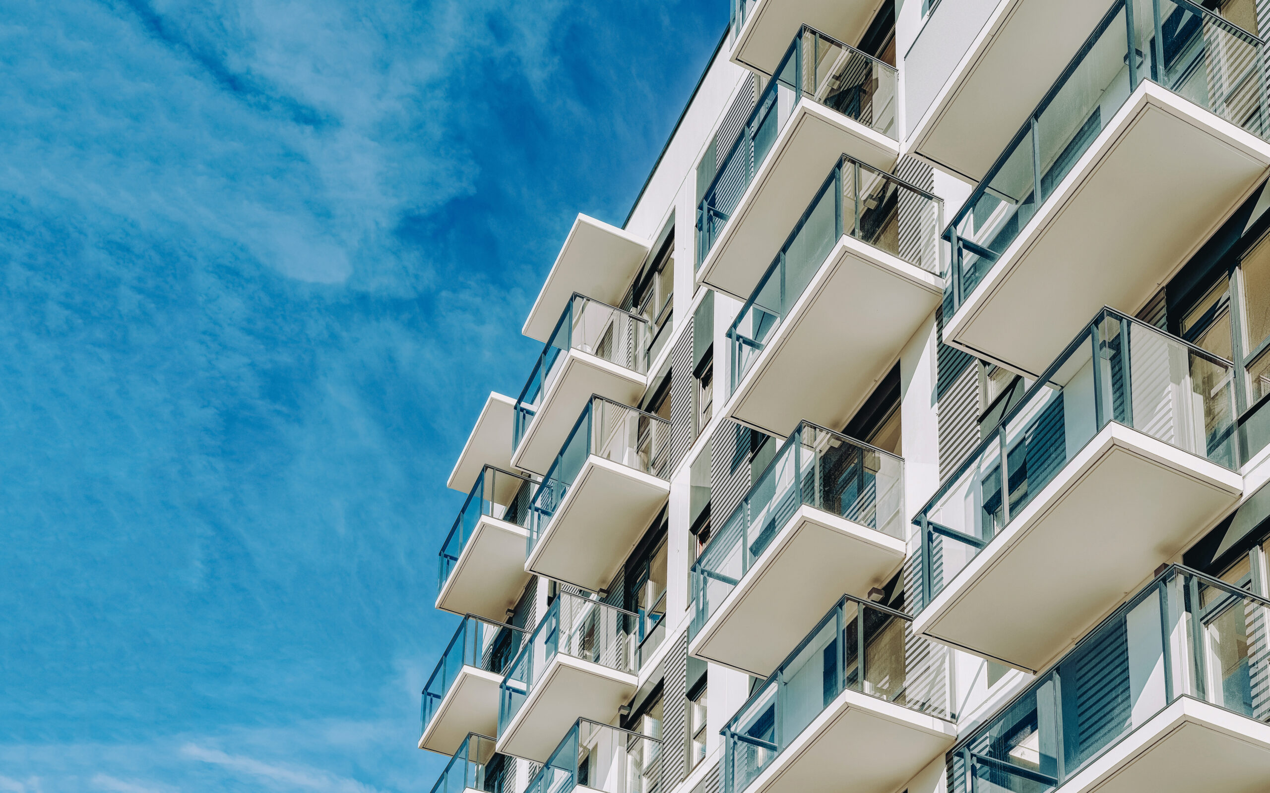 Detail of Modern residential apartment flat building exterior. Fragment of New luxury house and home complex. Part of City Real estate property and condo architecture. Copy space. Blue sky