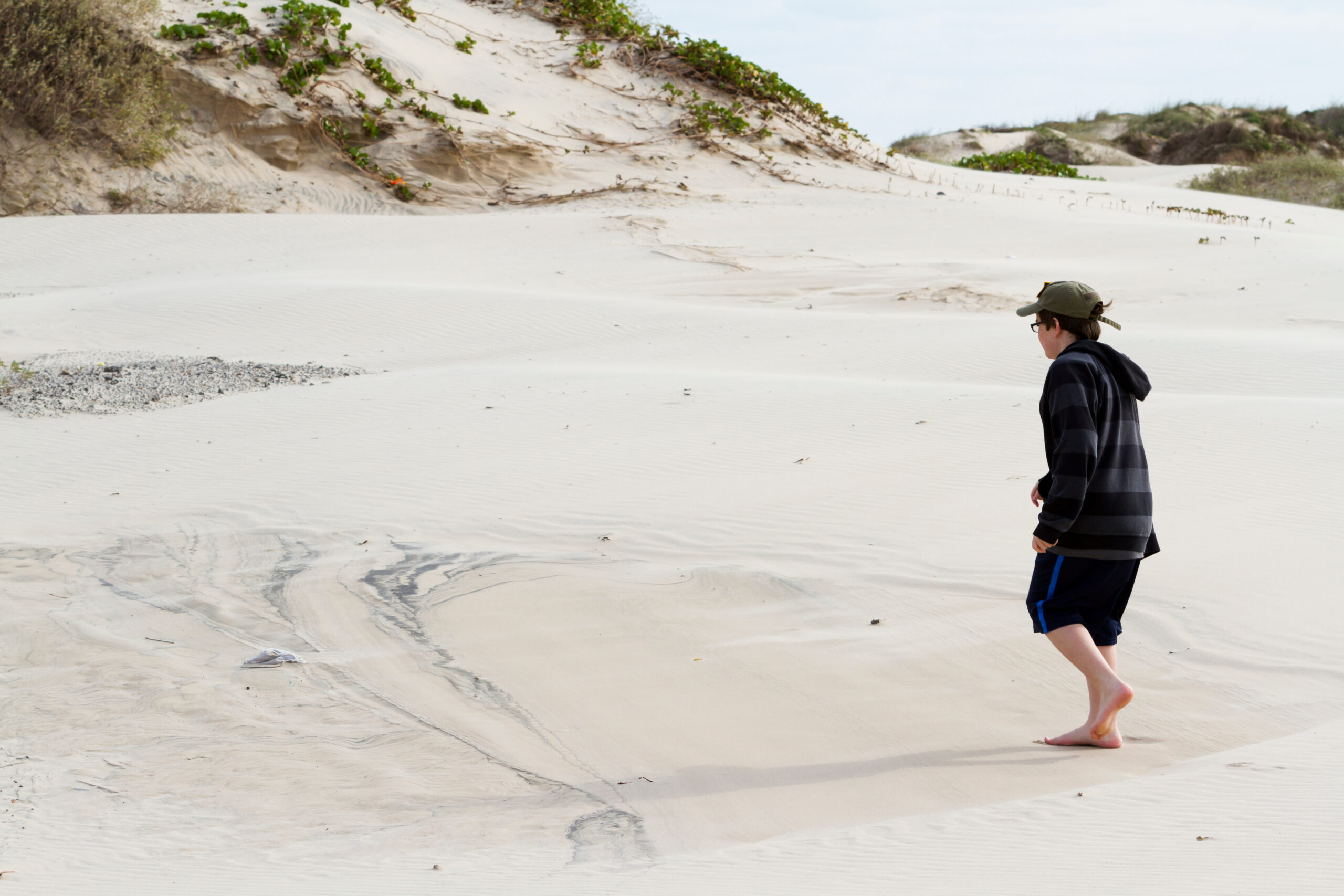 boy walking in sand